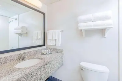a bathroom with a sink and a toilet and a mirror at La Quinta by Wyndham Clifton/Rutherford in Clifton