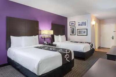 two beds in a hotel room with purple walls at La Quinta by Wyndham Clifton/Rutherford in Clifton