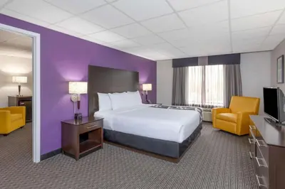 a hotel room with a bed and a purple wall at La Quinta by Wyndham Clifton/Rutherford in Clifton