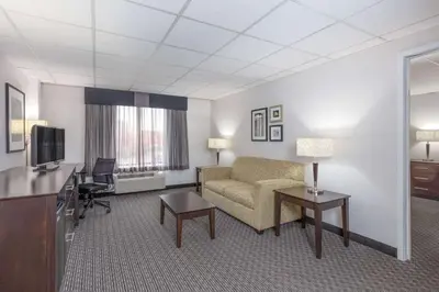 a hotel room with a couch and a television at La Quinta by Wyndham Clifton/Rutherford in Clifton