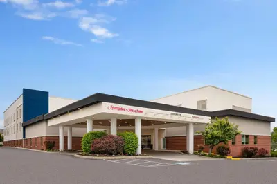 a large white building with a shopping center at Hampton Inn & Suites Hershey in Hershey