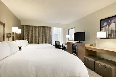 a hotel room with a white bed and a tv at Hampton Inn & Suites Hershey in Hershey