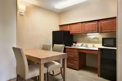 a small kitchen with a table and a kitchen with a refrigerator at Hampton Inn & Suites Hershey in Hershey