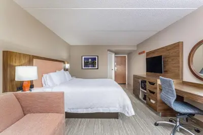 a hotel room with a bed and a desk and a television at Hampton Inn Harrisburg-East/Hershey in Harrisburg