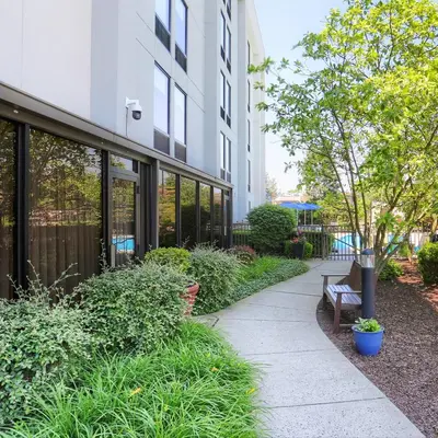 a sidewalk in front of a building with a bench at Hampton Inn Harrisburg-East/Hershey in Harrisburg