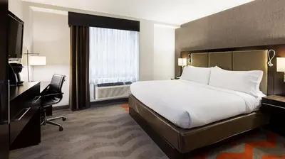 a hotel room with a bed and a desk and a television at Holiday Inn Lower East Side by IHG in New York