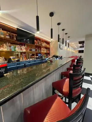 a restaurant with a bar with red chairs at Holiday Inn Lower East Side by IHG in New York