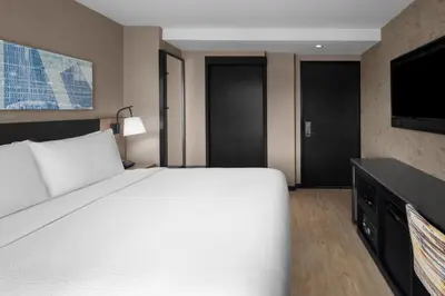 a bedroom with a large bed and a flat screen tv at Courtyard by Marriott New York World Trade Center Area in New York