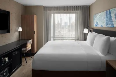a hotel room with a large bed and a window at Courtyard by Marriott New York World Trade Center Area in New York