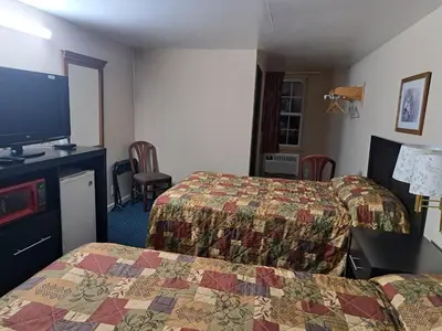 a hotel room with two beds and a flat screen tv at Pennswoods Inn in Manheim