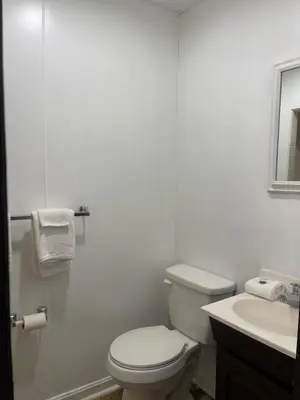a white bathroom with a toilet and a sink at Pennswoods Inn in Manheim