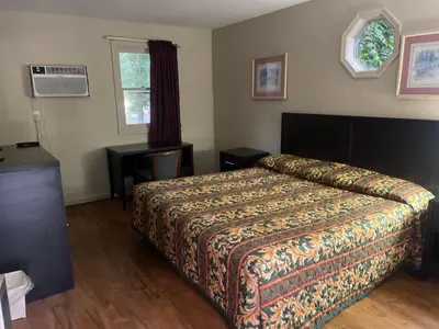 a bedroom with a bed and a table and a window at Pennswoods Inn in Manheim