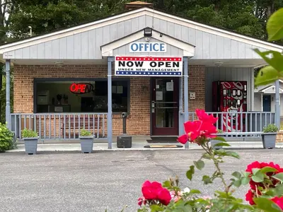 an office now open sign in a brick building at Pennswoods Inn in Manheim