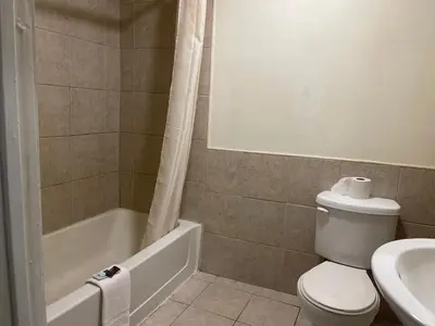 a bathroom with a toilet and a tub and a sink at Pennswoods Inn in Manheim