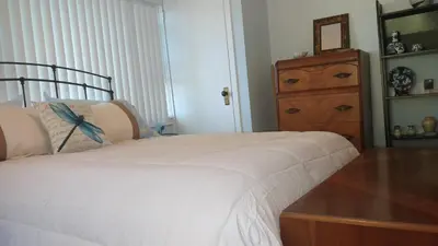 a bedroom with a white bed and a wooden dresser at Maurrocks - A Pocono Mountains B&B in Mount Pocono
