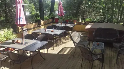 a row of tables and chairs on a wooden deck at Maurrocks - A Pocono Mountains B&B in Mount Pocono