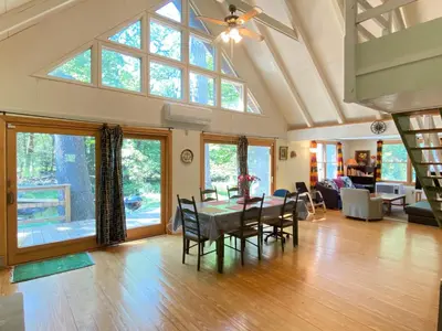 a dining room and living room with a table and chairs at Secluded Greekside Cabin near Camelback in Tannersville