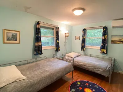 a bedroom with two beds and two windows at Secluded Greekside Cabin near Camelback in Tannersville