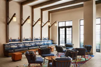 a waiting room with chairs and tables and mirrors at Renaissance New York Chelsea Hotel in New York