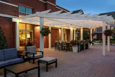 a patio with tables and chairs under a white pergola at Homewood Suites by Hilton Harrisburg East-Hershey Area in Harrisburg