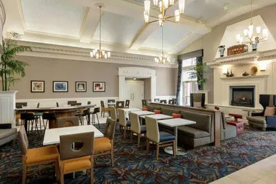 a restaurant with tables and chairs and a fireplace at Homewood Suites by Hilton Harrisburg East-Hershey Area in Harrisburg