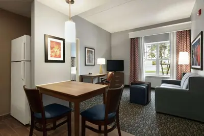 a living room with a table and a couch and a kitchen at Homewood Suites by Hilton Harrisburg East-Hershey Area in Harrisburg