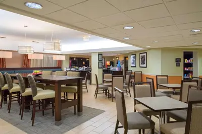 a restaurant with tables and chairs and a bar at Larkspur Landing Carlisle in Carlisle