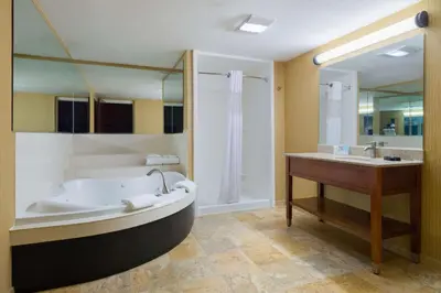 a large bathroom with a tub and a sink at Larkspur Landing Carlisle in Carlisle