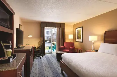 a hotel room with a bed and a desk and a television at Hilton Garden Inn Lancaster in Lancaster