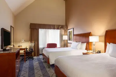 a hotel room with two beds and a desk and a television at Hilton Garden Inn Lancaster in Lancaster