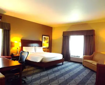 a hotel room with a bed and a chair and a window at Hilton Garden Inn Lancaster in Lancaster