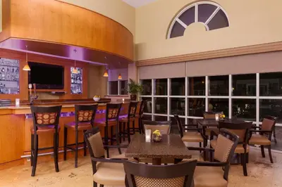 a restaurant with tables and chairs and a bar at Hilton Garden Inn Lancaster in Lancaster