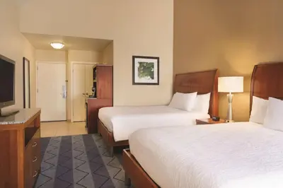a hotel room with two beds and a flat screen tv at Hilton Garden Inn Lancaster in Lancaster