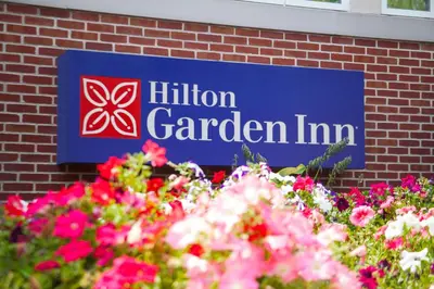 a sign for a garden inn with pink flowers at Hilton Garden Inn Lancaster in Lancaster