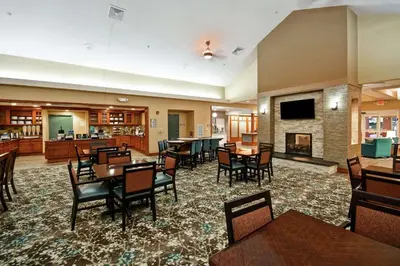 a restaurant with tables and chairs and a fireplace at Homewood Suites by Hilton Lancaster in Lancaster