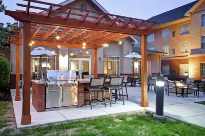 a patio with an outdoor kitchen and tables and chairs at Homewood Suites by Hilton Lancaster in Lancaster
