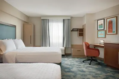 a hotel room with two beds and a desk at Hampton Inn Lancaster in Lancaster
