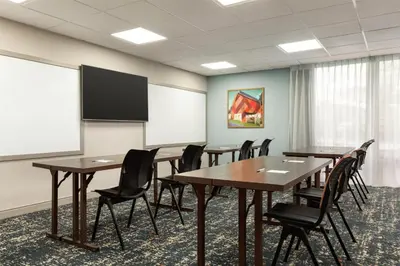 a conference room with tables and chairs and a screen at Hampton Inn Lancaster in Lancaster