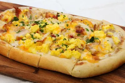 a pizza sitting on top of a wooden cutting board at Hilton Harrisburg near Hershey Park in Harrisburg