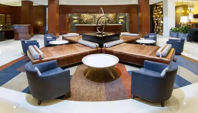 a lobby with a couch and tables and chairs at Hilton Harrisburg near Hershey Park in Harrisburg