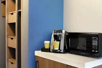 a microwave sitting on a counter with two drinks at Hilton Garden Inn Harrisburg East in Harrisburg