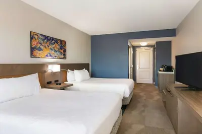 a hotel room with two beds and a flat screen tv at Hilton Garden Inn Harrisburg East in Harrisburg
