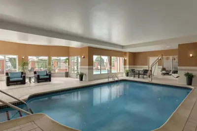 a pool in a hotel lobby with chairs and tables at Hilton Garden Inn Harrisburg East in Harrisburg