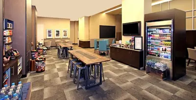 a restaurant with tables and chairs and a grocery store at Hilton Garden Inn West 35th Street in New York