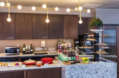 a kitchen with a counter with food and drinks at Hilton Wilmington/Christiana in Newark