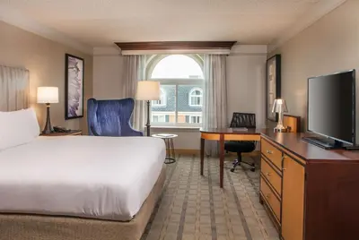 a hotel room with a bed and a desk with a television at Hilton Wilmington/Christiana in Newark