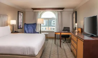a hotel room with a bed and a desk with a television at Hilton Wilmington/Christiana in Newark