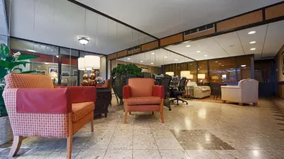 a lobby with chairs and tables in a store at West Gate Inn Nyack in Nyack