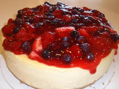 a cake with berries on top of it on a plate at West Gate Inn Nyack in Nyack