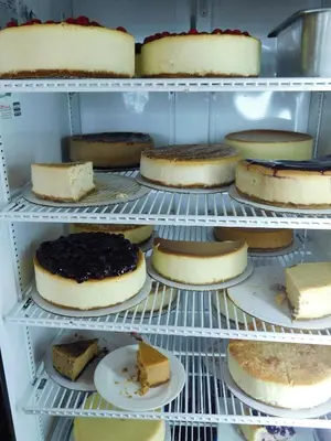 a refrigerator filled with lots of cakes and cheeses at West Gate Inn Nyack in Nyack